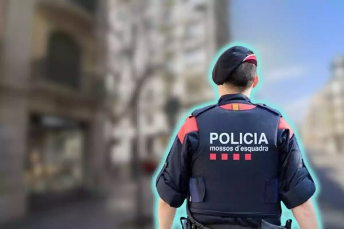 Un agente de los Mossos d'Esquadra de espaldas en una calle urbana.