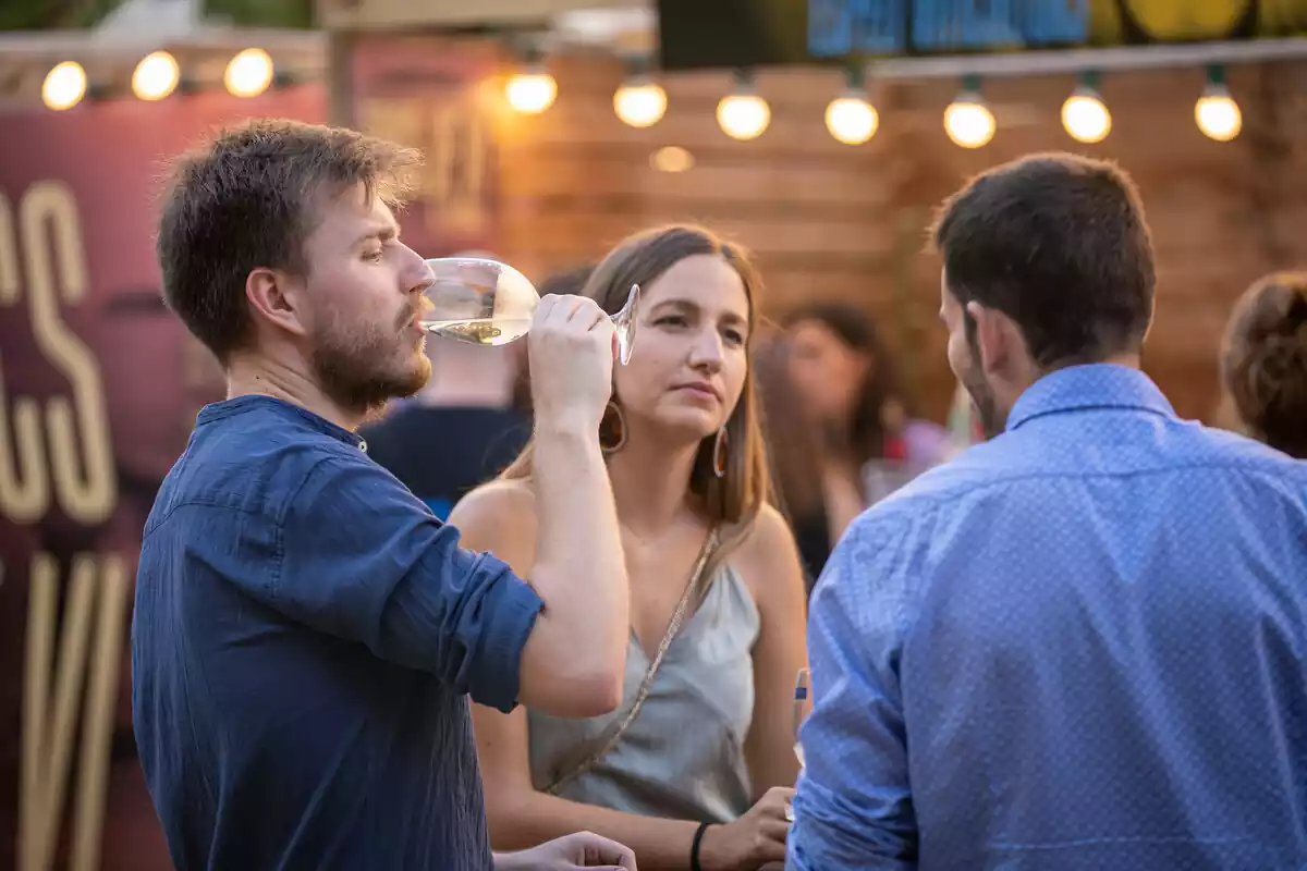 Personas bebiendo vino en una feria de Girona