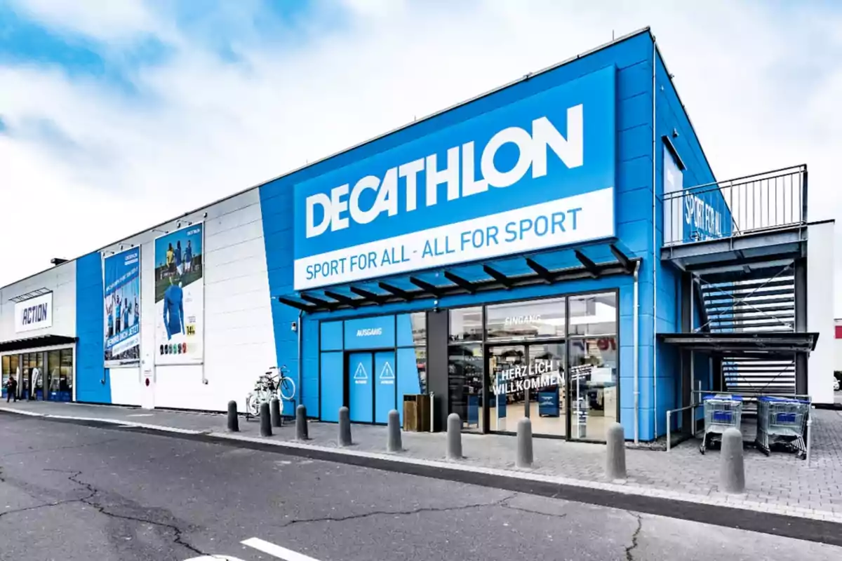 Fachada de una tienda Decathlon con letreros y carteles promocionales en la entrada.