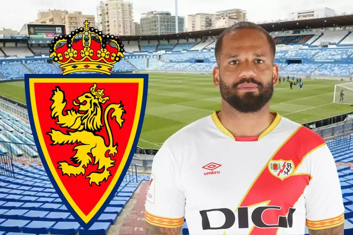 Un jugador de fútbol con la camiseta del Rayo Vallecano posando frente a un estadio de fútbol con el escudo del Real Zaragoza en primer plano.