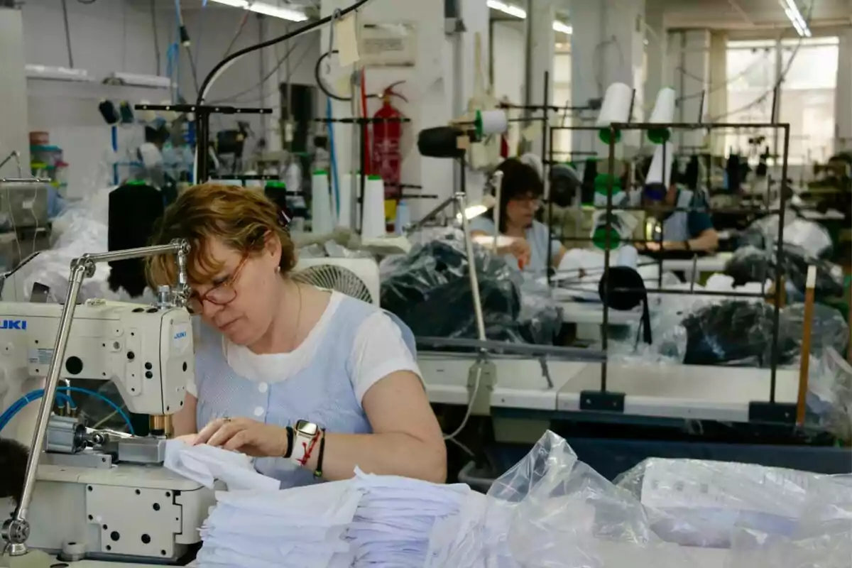 Mujer cosiendo en un taller de costura