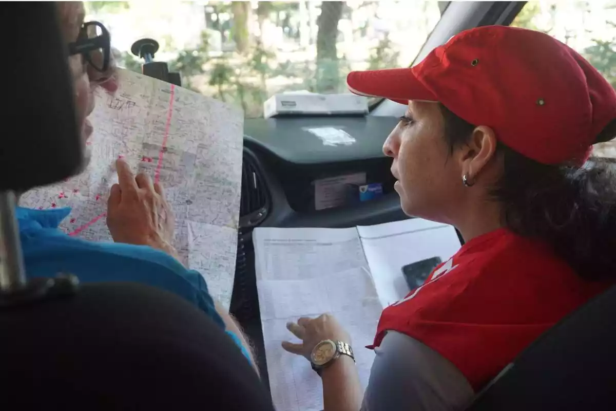Dos voluntarias de Cruz Roja con unos mapas en la mano