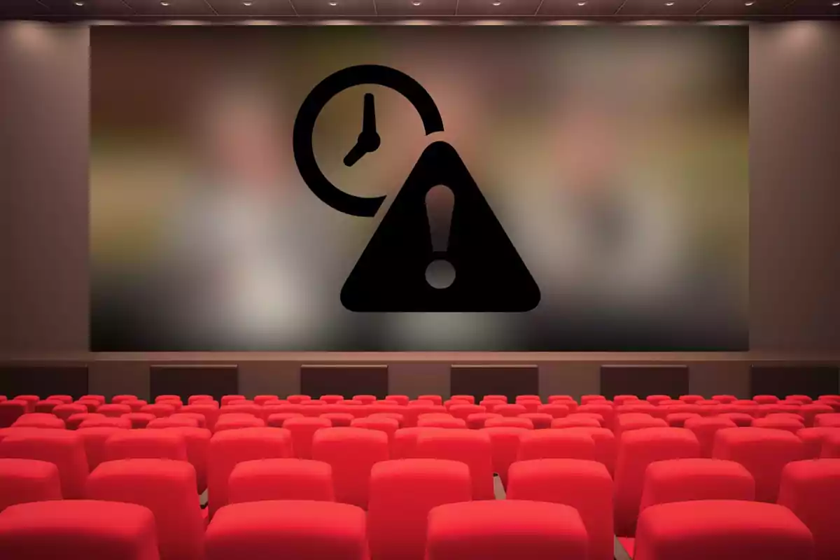 Sala de cine vacía con una pantalla que muestra un ícono de advertencia y un reloj.