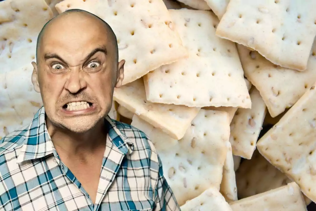 Hombre con expresión de enojo frente a un fondo de galletas saladas.