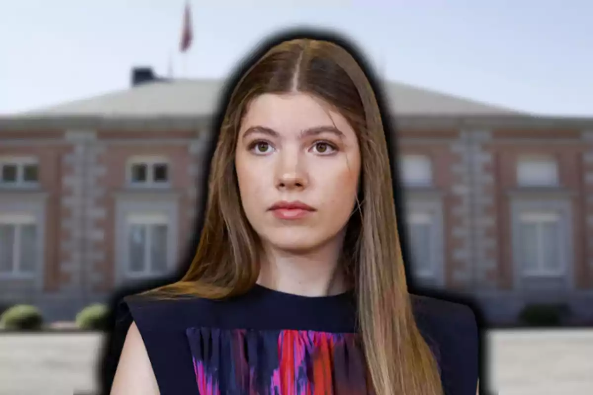 Una mujer de cabello largo y lacio con un vestido oscuro está frente a un edificio de ladrillo con ventanas grandes.