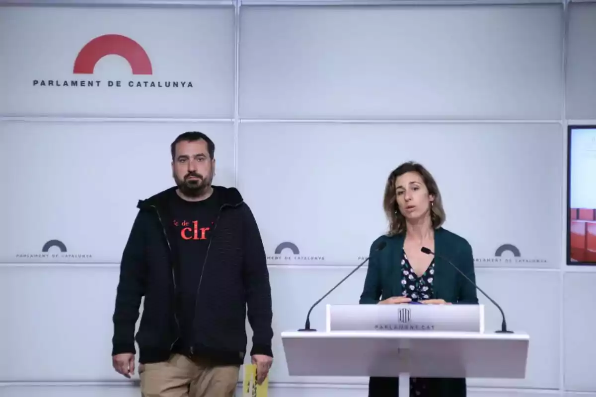 Dos personas en una conferencia de prensa en el Parlamento de Cataluña.