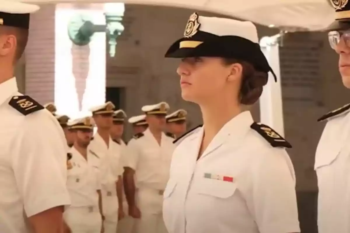 Grupo de oficiales navales en formación con uniformes blancos.