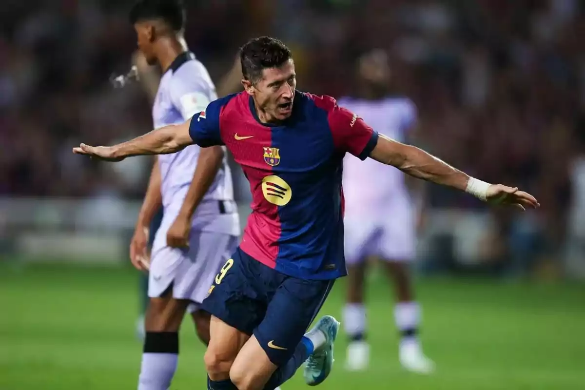 Jugador de fútbol celebrando un gol con los brazos extendidos, vistiendo el uniforme del FC Barcelona.