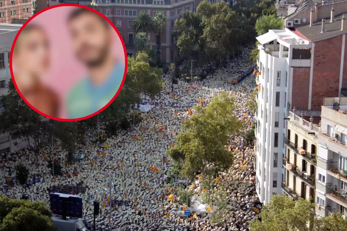 Una multitud de personas con sombreros blancos y banderas se congrega en una calle rodeada de edificios y árboles, con un círculo rojo en la esquina superior izquierda que contiene una imagen borrosa de dos personas.