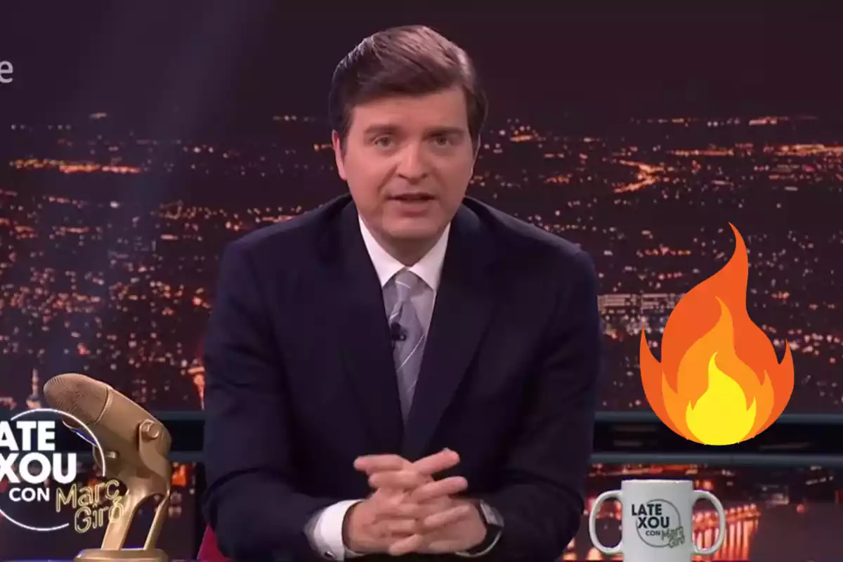 Montaje con una imagen de Marc Giró en su programa "Late Xou con Marc Giró" de RTVE. A la derecha un emoticono de fuego.