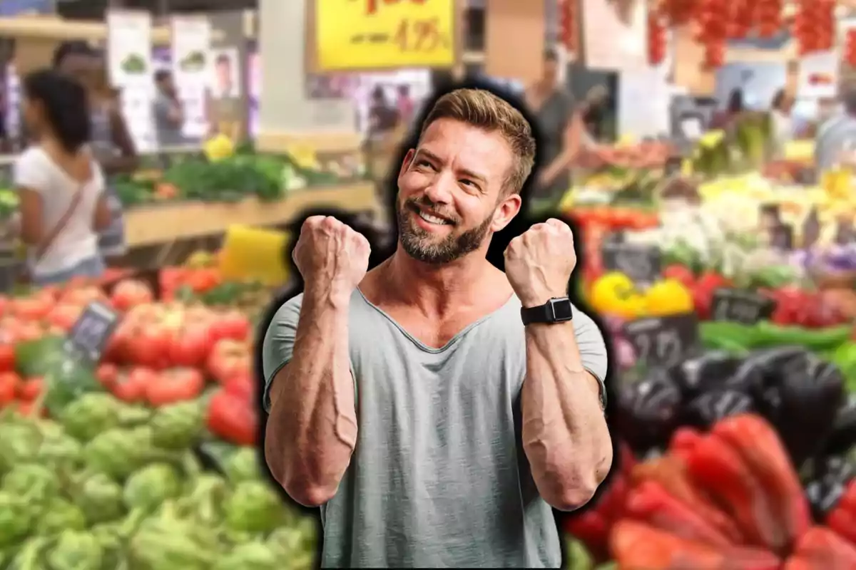 Un hombre sonriente con los puños levantados en un mercado de frutas y verduras.