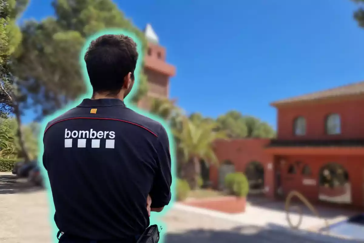 Un bombero de espaldas con un uniforme que dice "bombers" en un entorno al aire libre con edificios y árboles.