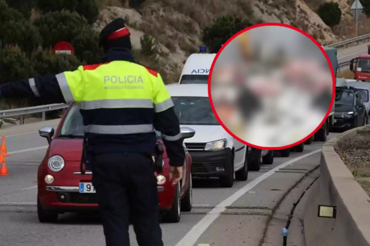 Un agente de policía de tráfico detiene vehículos en una carretera mientras se observa una fila de coches.