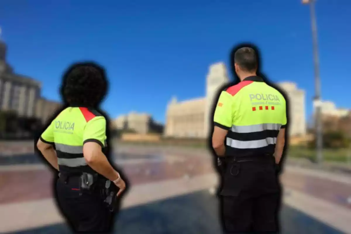 Dos agentes de policía con uniformes de alta visibilidad de espaldas en un entorno urbano.