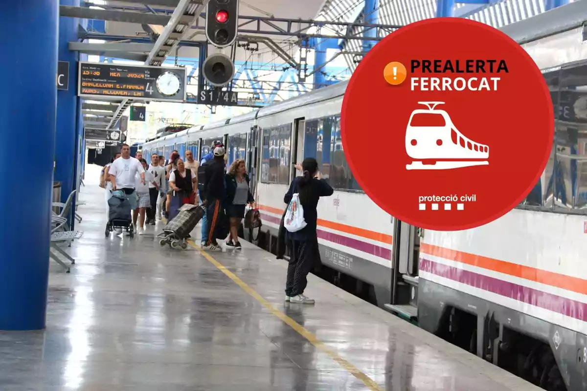 Personas en un andén de tren con un cartel de prealerta Ferrocat de protección civil.