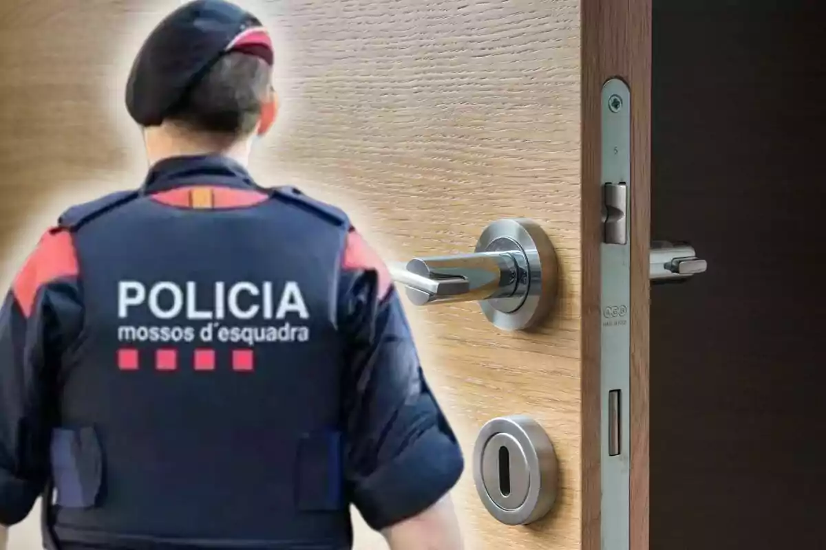 Un agente de los Mossos d'Esquadra de espaldas junto a una puerta entreabierta con una cerradura moderna.