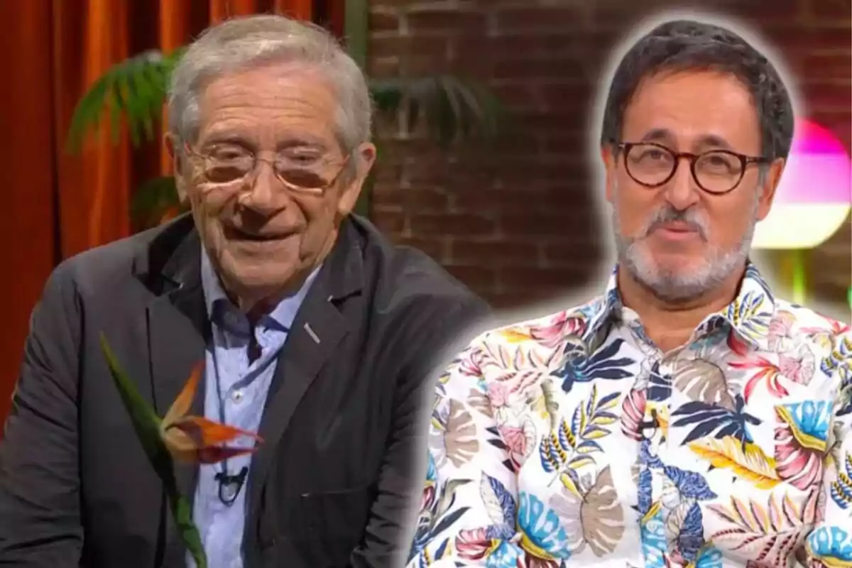 Dos hombres sonríen en un set de televisión con fondo de ladrillos y plantas.