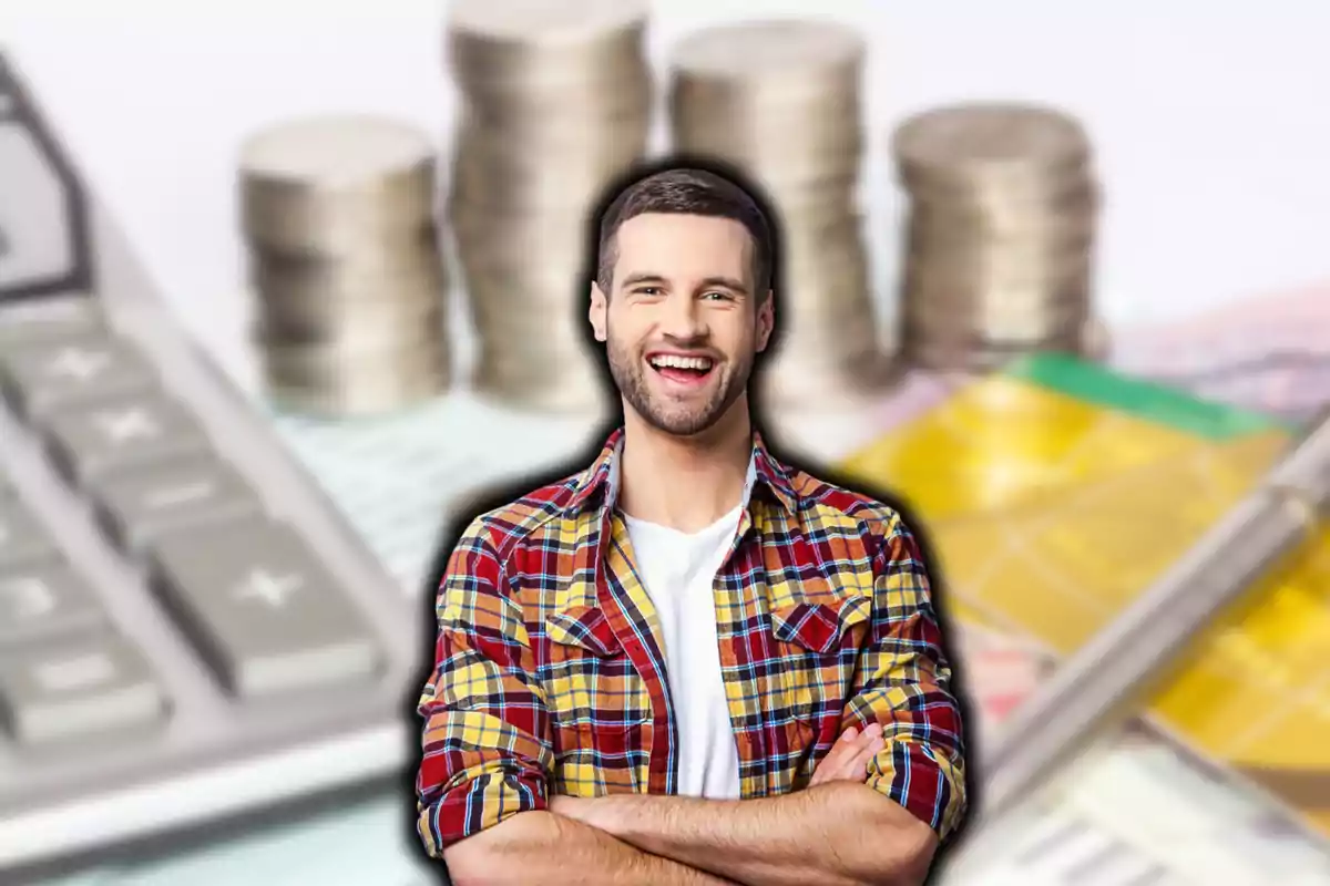 Un hombre sonriente con camisa a cuadros frente a una calculadora y pilas de monedas.