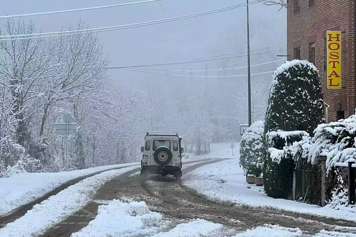 Imagen de un todoterreno alejándose en una carretera cubierta de nieve