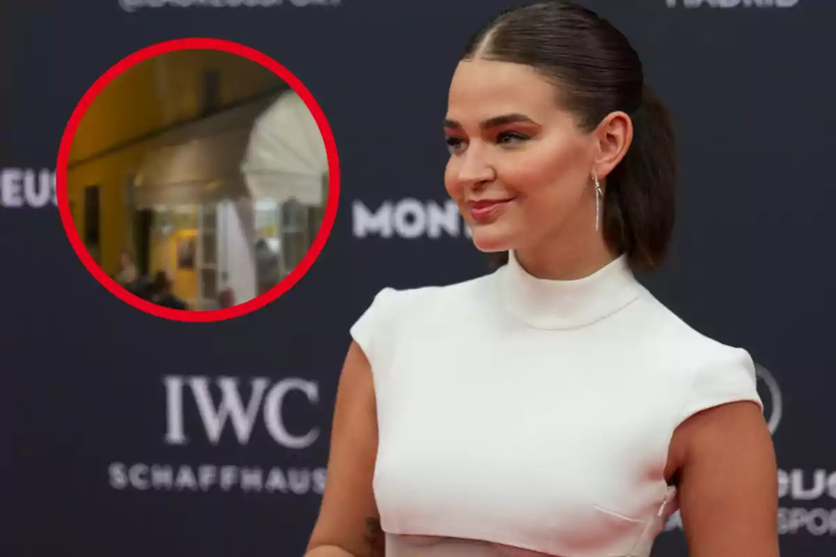 Mujer con vestido blanco en un evento con fondo negro y logotipos, con un círculo rojo resaltando una escena de un restaurante.