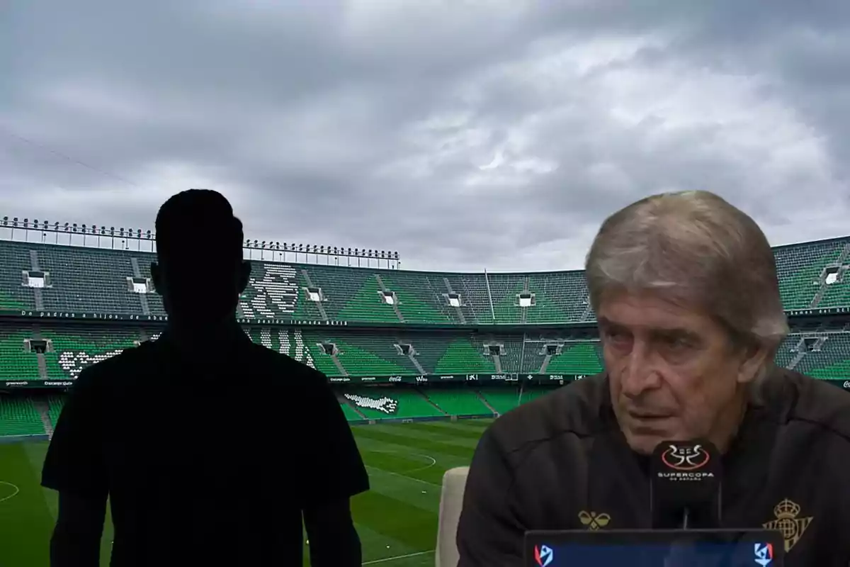 Un hombre mayor hablando en una conferencia de prensa en un estadio de fútbol con una silueta de una persona en el fondo.