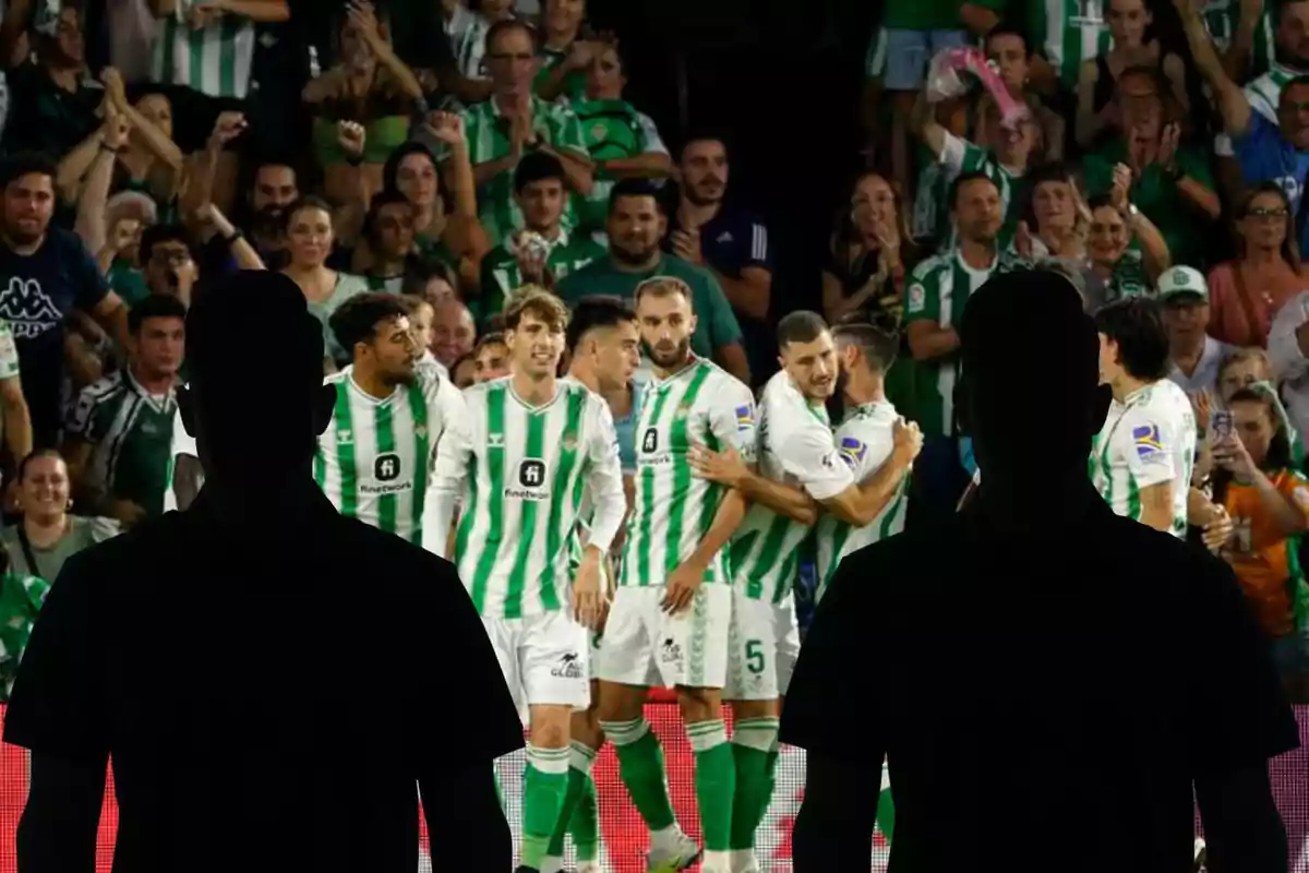 Montage con el equipo del Real Betis celebrando un gol y dos figuras negras, una a la izquierda y otra a la derecha