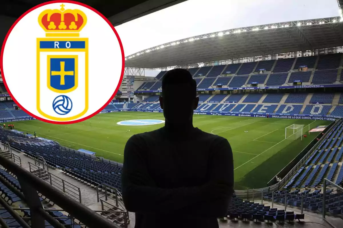 Una persona de pie en un estadio de fútbol vacío con el escudo del Real Oviedo en la esquina superior izquierda.