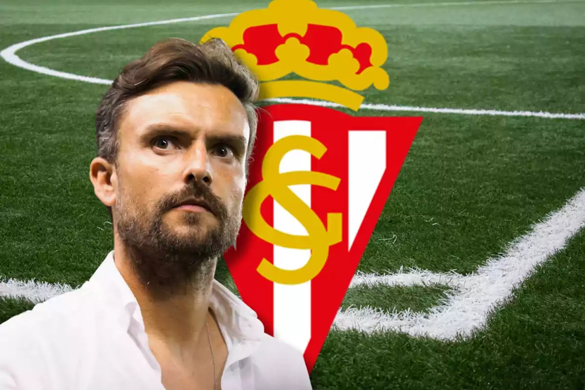 Un hombre con barba y cabello oscuro, vestido con una camisa blanca, está frente a un campo de fútbol con el escudo del Sporting de Gijón en el fondo.