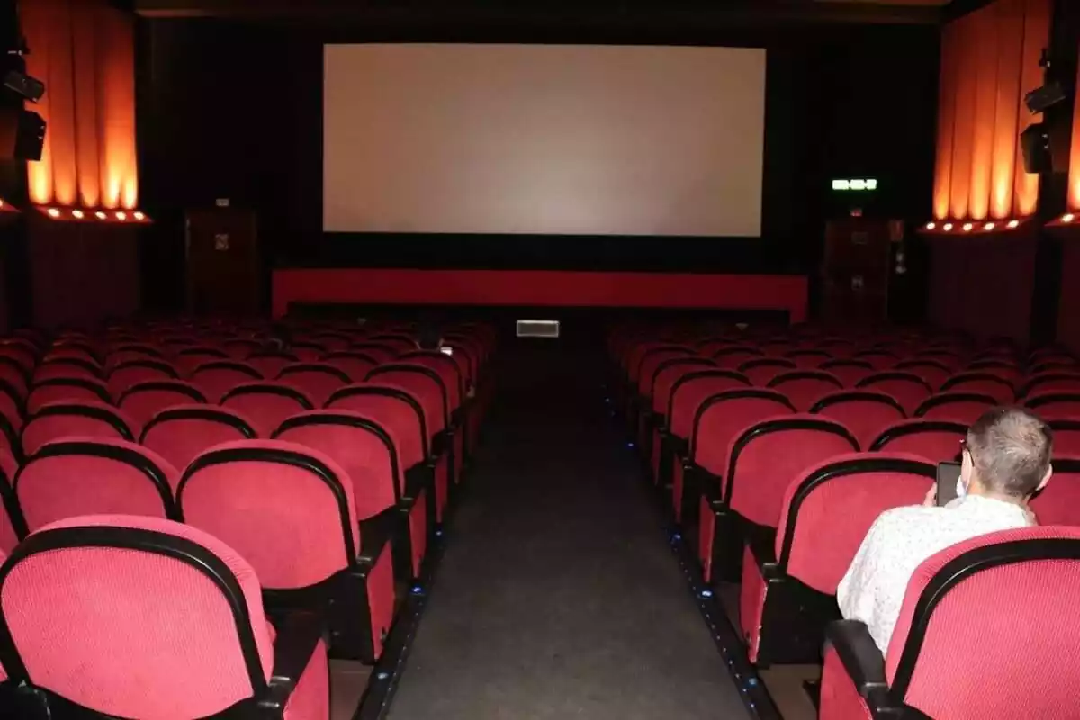 Una sala de cine con un hombre en una de las butacas