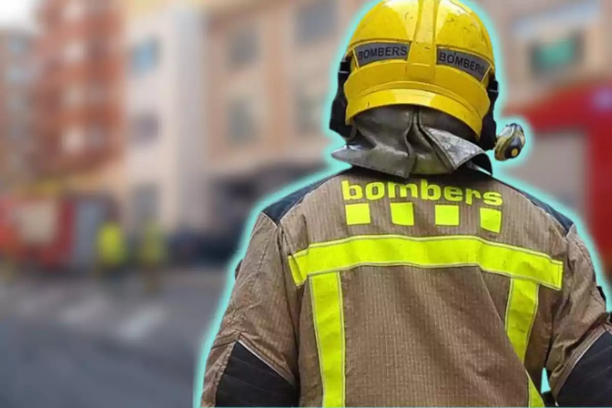 Bombero de espaldas con uniforme y casco amarillo en una escena urbana desenfocada.