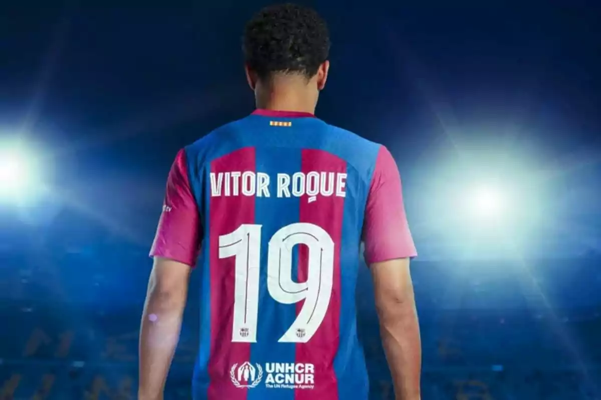 Jugador de fútbol con la camiseta número 19 de Vitor Roque en un estadio iluminado.